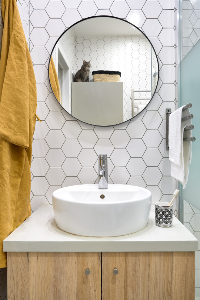 Exemple d'une salle d'eau tendance en bois clair avec un placard à porte plane, un carrelage blanc, une vasque et un plan de toilette blanc.