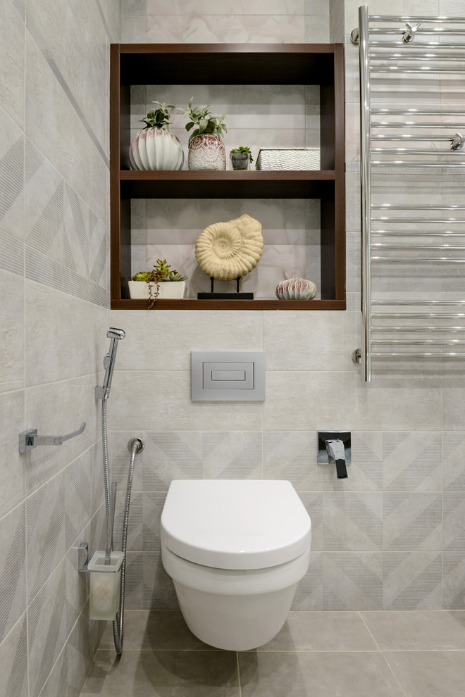 На фото: большая главная ванная комната в современном стиле с плоскими фасадами, белыми фасадами, угловой ванной, угловым душем, инсталляцией, серой плиткой, керамической плиткой, серыми стенами, полом из керамической плитки, врезной раковиной, столешницей из искусственного камня, серым полом, душем с распашными дверями, белой столешницей и гигиеническим душем