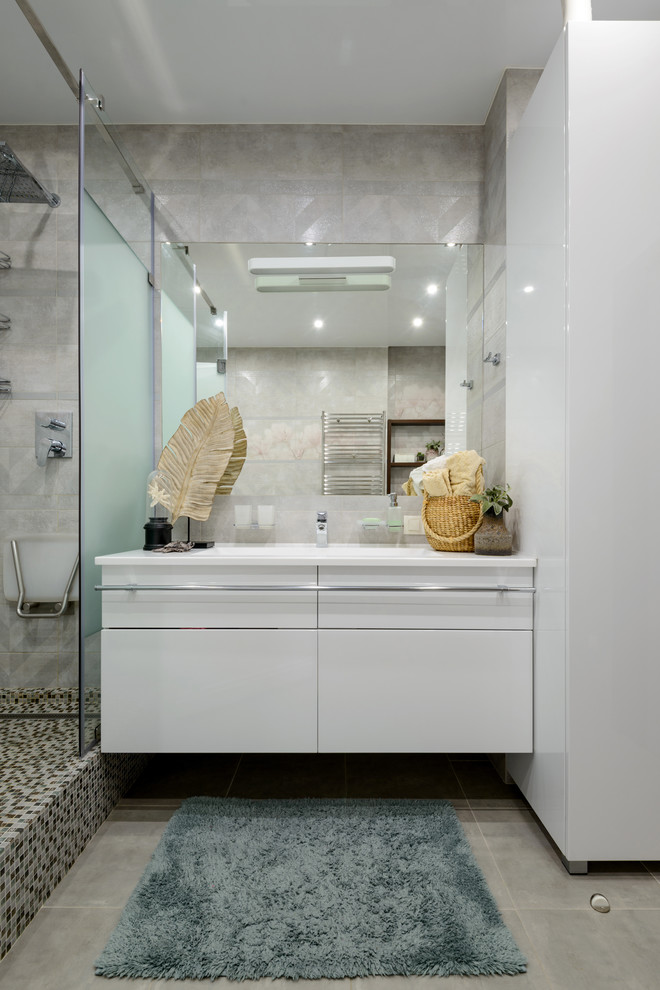 Свежая идея для дизайна: большая главная ванная комната в современном стиле с плоскими фасадами, белыми фасадами, угловым душем, серой плиткой, керамической плиткой, серыми стенами, полом из керамической плитки, врезной раковиной, столешницей из искусственного камня, серым полом, душем с распашными дверями и белой столешницей - отличное фото интерьера