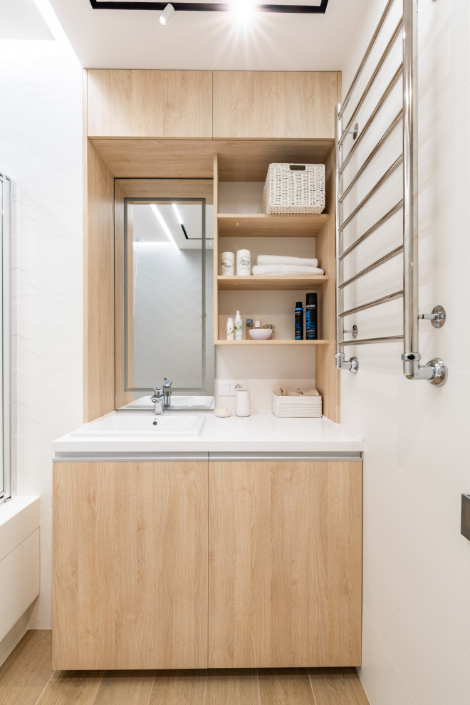 Cette image montre une petite salle d'eau beige et blanche design en bois clair avec un placard à porte plane, un mur blanc, un lavabo posé, un sol blanc, un plan de toilette blanc et meuble-lavabo encastré.