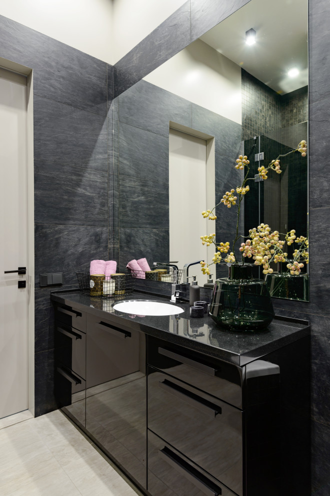 Idéer för stora funkis svart en-suite badrum, med släta luckor, svarta skåp, svart kakel, keramikplattor, svarta väggar, klinkergolv i keramik, ett undermonterad handfat, bänkskiva i akrylsten och grått golv