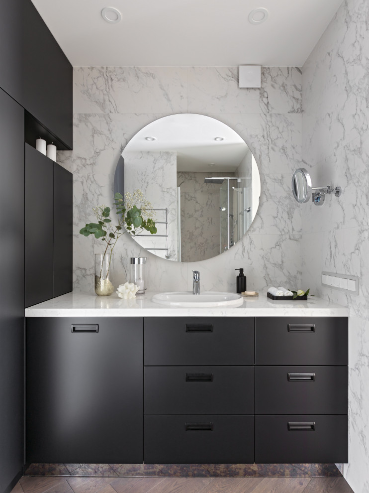 Small contemporary bathroom in Other with flat-panel cabinets, black cabinets, a wall mounted toilet, white tiles, porcelain tiles, white walls, dark hardwood flooring, a submerged sink, engineered stone worktops, brown floors, a hinged door, white worktops, a shower bench, a single sink and a freestanding vanity unit.