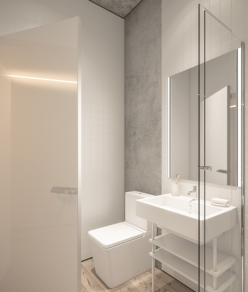 Idéer för ett litet nordiskt badrum med dusch, med grå skåp, en dusch i en alkov, en toalettstol med hel cisternkåpa, vit kakel, grå väggar, mellanmörkt trägolv, ett piedestal handfat och bänkskiva i akrylsten
