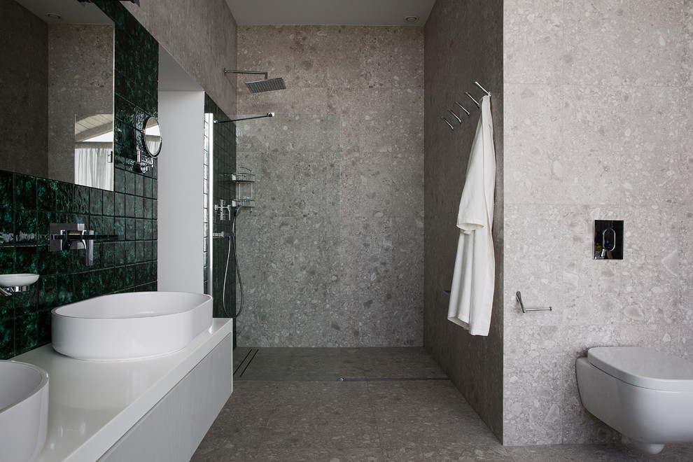 Inredning av ett modernt stort badrum med dusch, med skåp i shakerstil, grå skåp, ett badkar med tassar, våtrum, ett urinoar, grå kakel, perrakottakakel, grå väggar, mosaikgolv, ett piedestal handfat, bänkskiva i akrylsten, grått golv och dusch med skjutdörr