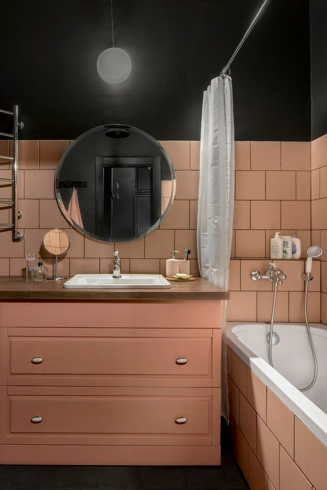 Inspiration för mellanstora industriella brunt en-suite badrum, med luckor med upphöjd panel, en dusch/badkar-kombination, porslinskakel, svarta väggar, klinkergolv i porslin, träbänkskiva, svart golv, dusch med duschdraperi och ett nedsänkt handfat