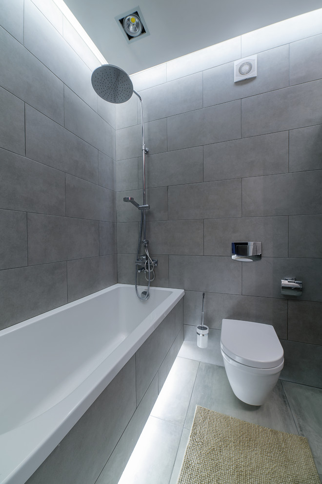 Ejemplo de cuarto de baño principal urbano con bañera empotrada y sanitario de pared