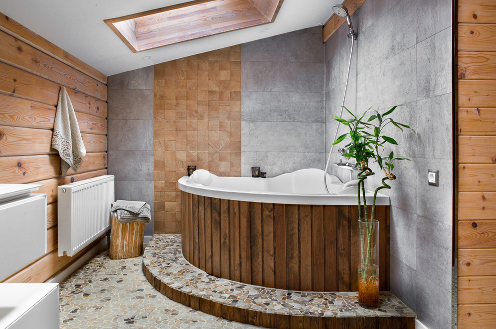 Пример оригинального дизайна: большая главная ванная комната в современном стиле с угловой ванной, серой плиткой, серым полом, душем над ванной, разноцветными стенами, открытым душем и полом из галечной плитки