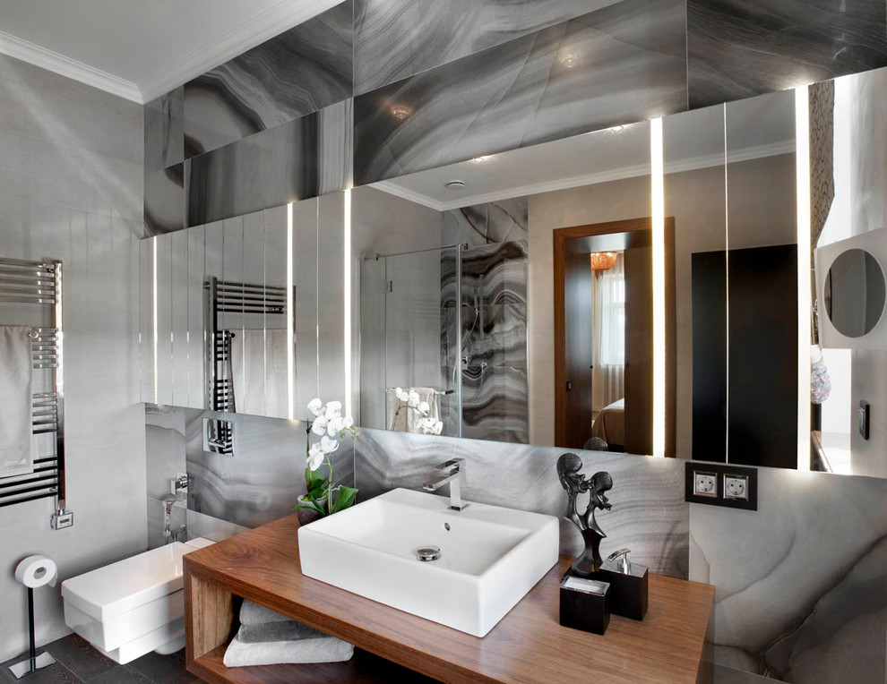 Idée de décoration pour une salle d'eau design avec un placard sans porte, une douche d'angle, WC suspendus, un carrelage gris, un carrelage de pierre et une vasque.