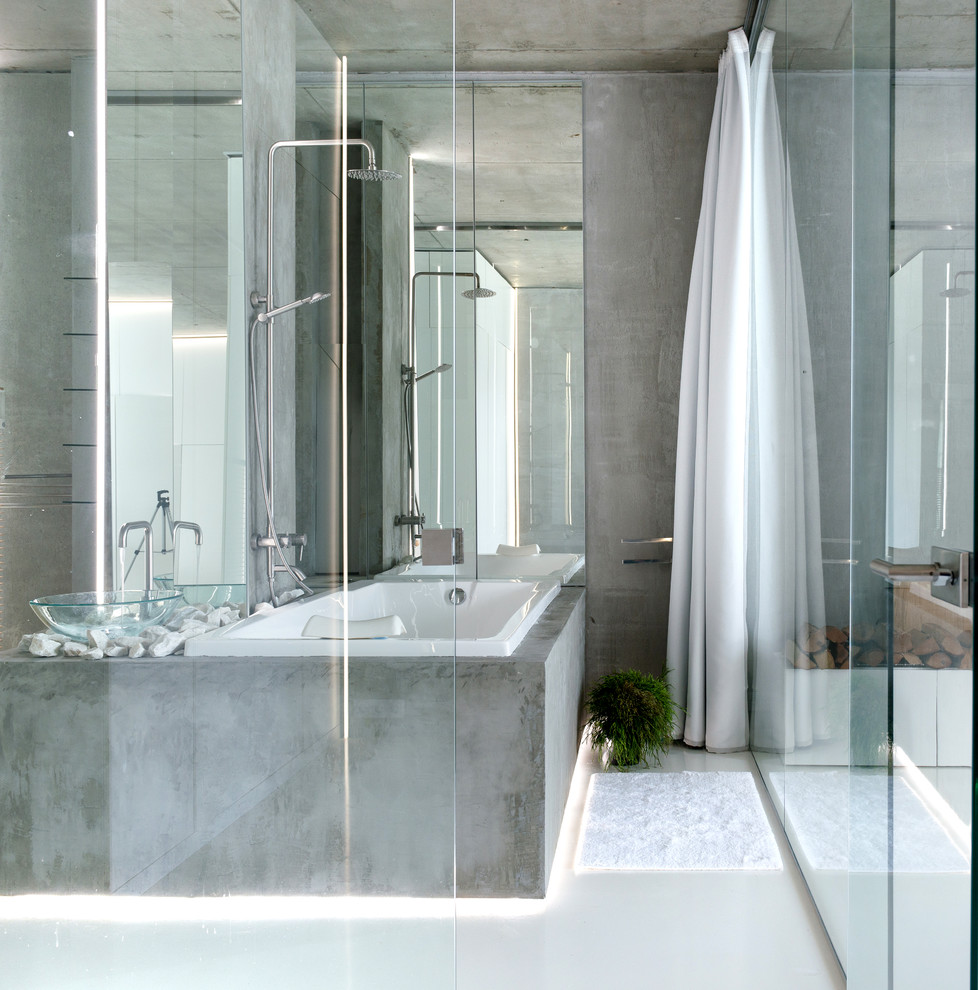 Idée de décoration pour une salle de bain principale design avec une baignoire posée et un mur gris.