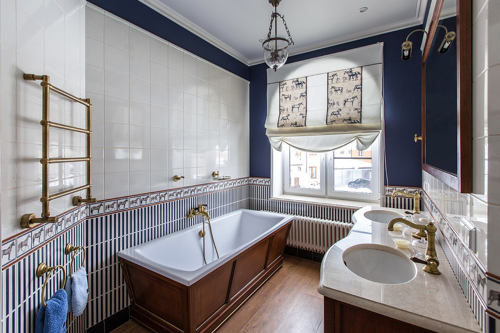 Idee per una stanza da bagno padronale tradizionale con vasca freestanding, piastrelle blu, piastrelle bianche, pareti blu, lavabo sottopiano e pavimento marrone