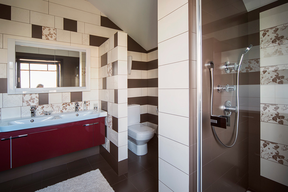 На фото: ванная комната среднего размера в современном стиле с плоскими фасадами, душем в нише, унитазом-моноблоком, коричневой плиткой, керамической плиткой, коричневыми стенами, полом из керамической плитки, настольной раковиной, столешницей из ламината, душевой кабиной и красными фасадами с