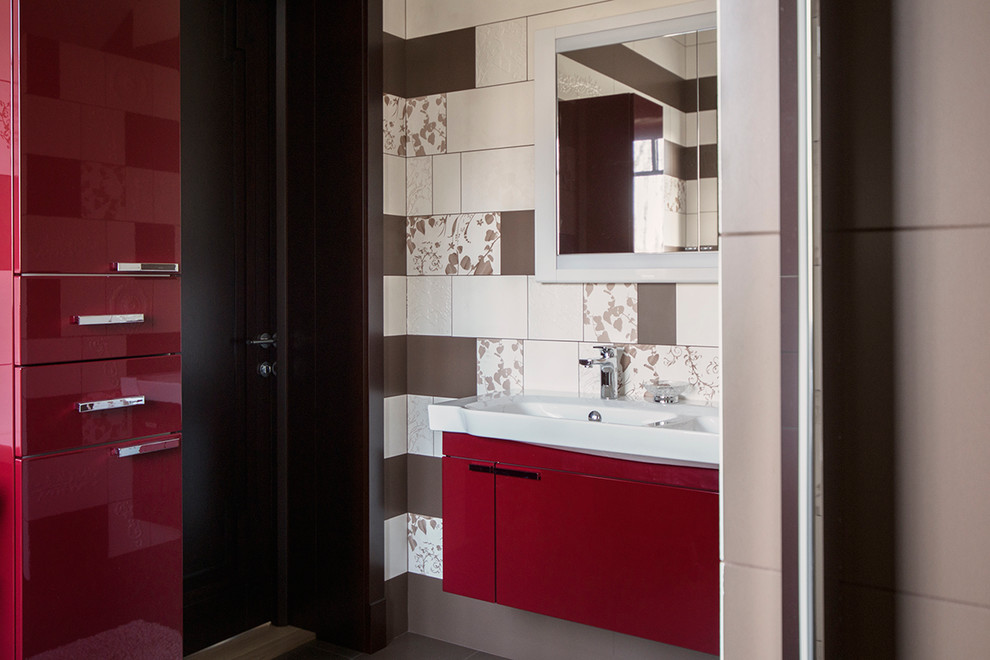 Cette image montre une salle de bain design de taille moyenne avec un placard à porte plane, des portes de placard rouges, WC à poser, un carrelage multicolore, des carreaux de céramique, un mur marron, un sol en carrelage de céramique, une vasque et un plan de toilette en stratifié.