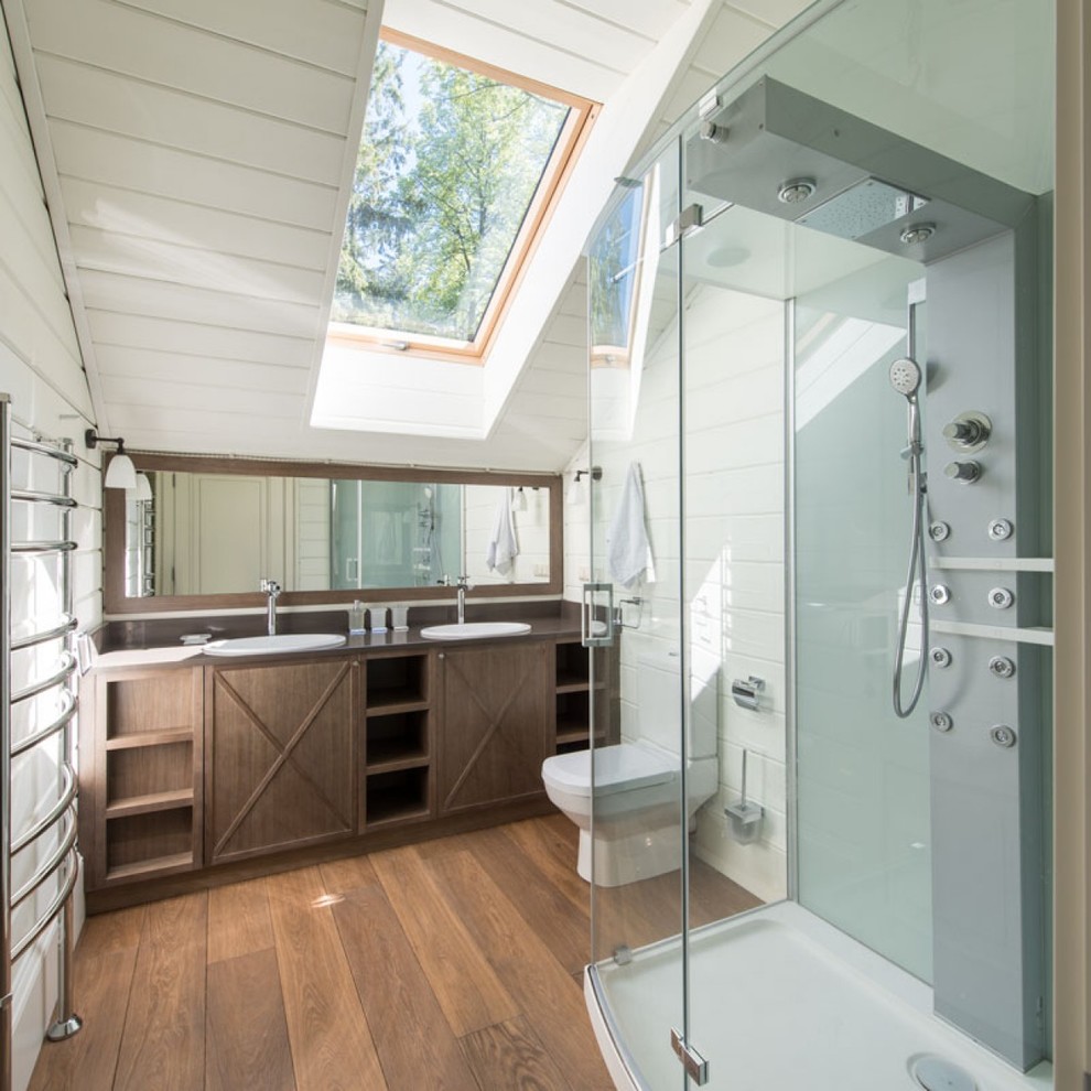 Exemple d'une salle de bain principale nature en bois foncé avec WC séparés, un mur blanc, un sol en bois brun, un lavabo posé, une douche d'angle, une cabine de douche à porte battante et un placard sans porte.