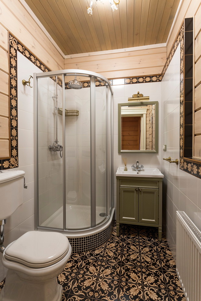 На фото: ванная комната в стиле кантри с фасадами с утопленной филенкой, зелеными фасадами, угловым душем, раздельным унитазом, белой плиткой, черной плиткой, бежевыми стенами, душевой кабиной и консольной раковиной