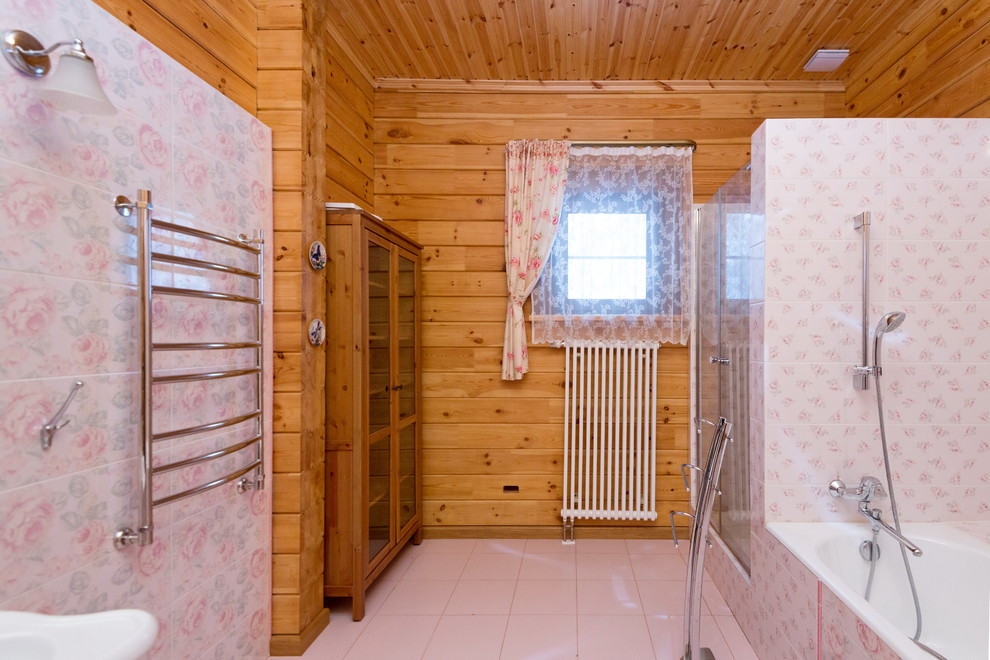 На фото: большая главная ванная комната в классическом стиле с ванной в нише, душем в нише, раздельным унитазом, розовой плиткой, керамической плиткой, желтыми стенами, полом из керамической плитки, раковиной с пьедесталом, розовым полом и душем с распашными дверями с