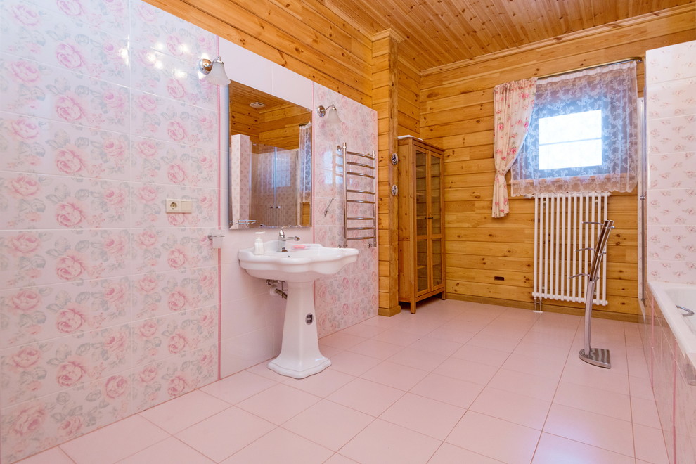 Стильный дизайн: большая главная ванная комната в классическом стиле с ванной в нише, душем в нише, раздельным унитазом, розовой плиткой, керамической плиткой, желтыми стенами, полом из керамической плитки, раковиной с пьедесталом, розовым полом и душем с распашными дверями - последний тренд