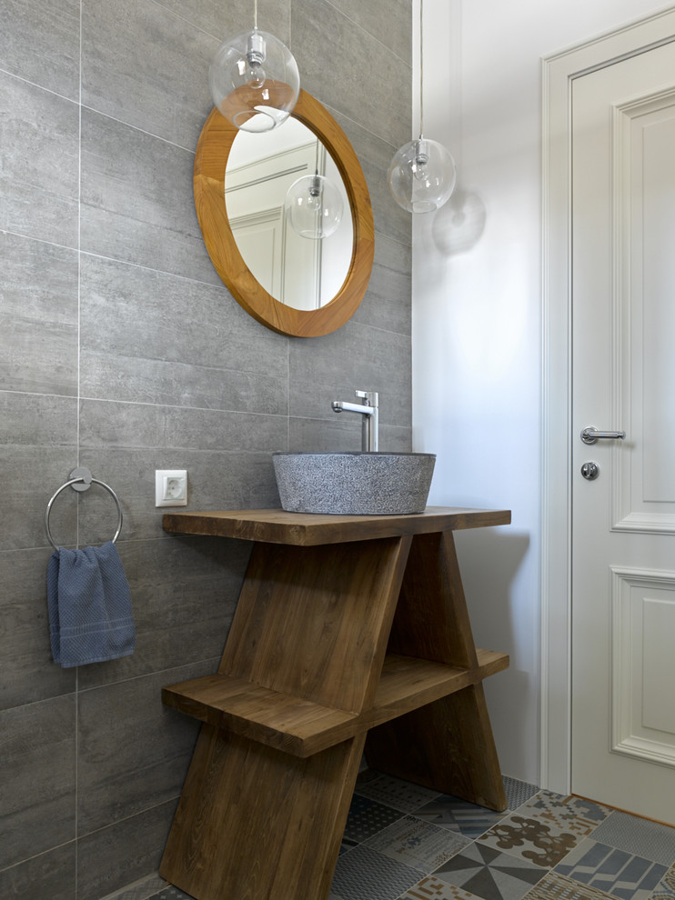 Imagen de cuarto de baño actual con armarios abiertos, baldosas y/o azulejos grises, paredes blancas, lavabo sobreencimera, encimera de madera y encimeras marrones