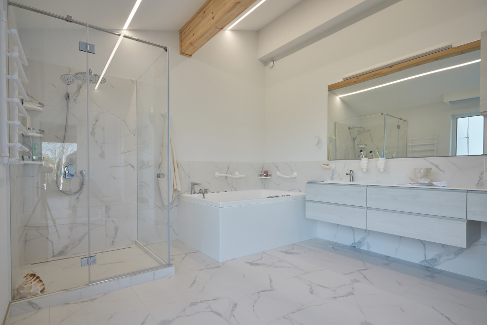 Свежая идея для дизайна: ванная комната в современном стиле с плоскими фасадами, серыми фасадами, угловой ванной, угловым душем, белой плиткой, белыми стенами и белым полом - отличное фото интерьера