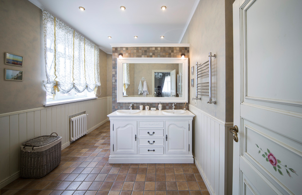 Bild på ett mellanstort vintage badrum med dusch, med luckor med upphöjd panel, vita skåp, perrakottakakel, beige väggar, klinkergolv i terrakotta, brunt golv, brun kakel och ett nedsänkt handfat