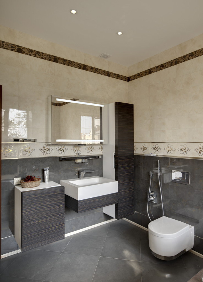 Idée de décoration pour une salle de bain design avec WC suspendus et un lavabo intégré.