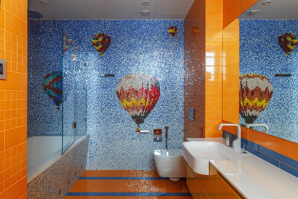 На фото: детская ванная комната среднего размера в стиле фьюжн с плоскими фасадами, оранжевыми фасадами, полновстраиваемой ванной и монолитной раковиной