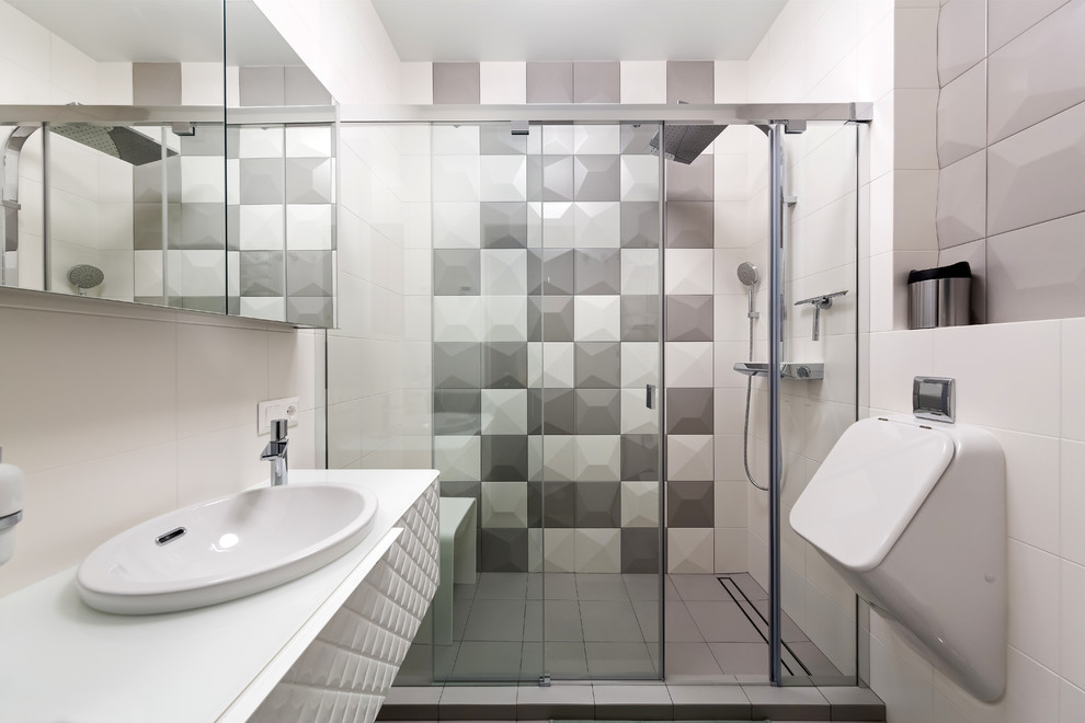 Пример оригинального дизайна: маленькая ванная комната с белыми фасадами, разноцветной плиткой, керамической плиткой, душевой кабиной, накладной раковиной, стеклянной столешницей, душем с раздвижными дверями, душем в нише и писсуаром для на участке и в саду