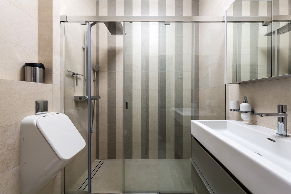 Стильный дизайн: маленькая ванная комната с плоскими фасадами, серыми фасадами, бежевой плиткой, цементной плиткой, душевой кабиной, монолитной раковиной, душем с раздвижными дверями, душем в нише и писсуаром для на участке и в саду - последний тренд