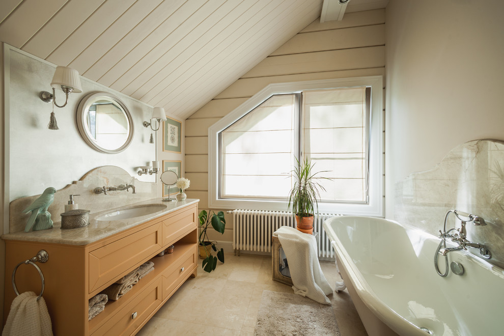 Immagine di una stanza da bagno padronale country con consolle stile comò, ante arancioni, vasca con piedi a zampa di leone, pareti beige, lavabo sottopiano, pavimento beige e top beige