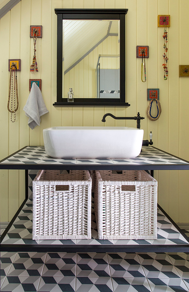 Modelo de cuarto de baño de estilo de casa de campo con paredes amarillas, armarios abiertos y lavabo sobreencimera