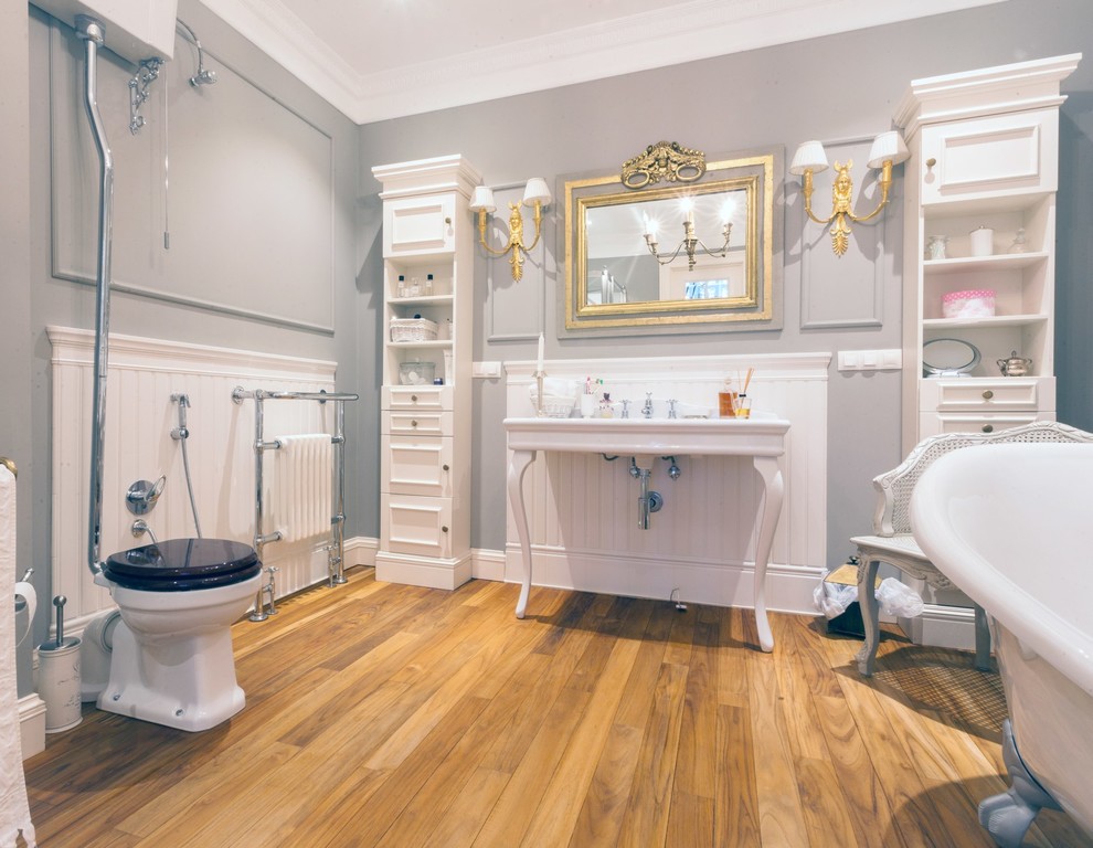Klassisches Badezimmer En Suite mit weißen Schränken, Löwenfuß-Badewanne, Wandtoilette mit Spülkasten, grauer Wandfarbe, Waschtischkonsole und braunem Holzboden in Moskau