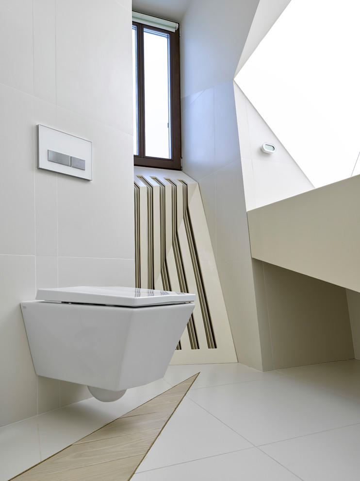 Inspiration för ett funkis badrum, med en vägghängd toalettstol, grå kakel och flerfärgat golv