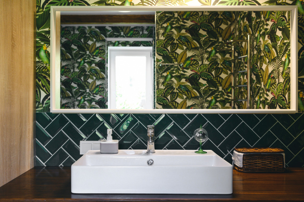 На фото: маленькая ванная комната со стиральной машиной в современном стиле с коричневыми фасадами, душем в нише, унитазом-моноблоком, зеленой плиткой, керамогранитной плиткой, зелеными стенами, полом из керамогранита, душевой кабиной, накладной раковиной, столешницей из дерева, бежевым полом, душем с распашными дверями, коричневой столешницей, тумбой под одну раковину, подвесной тумбой, балками на потолке и обоями на стенах для на участке и в саду с