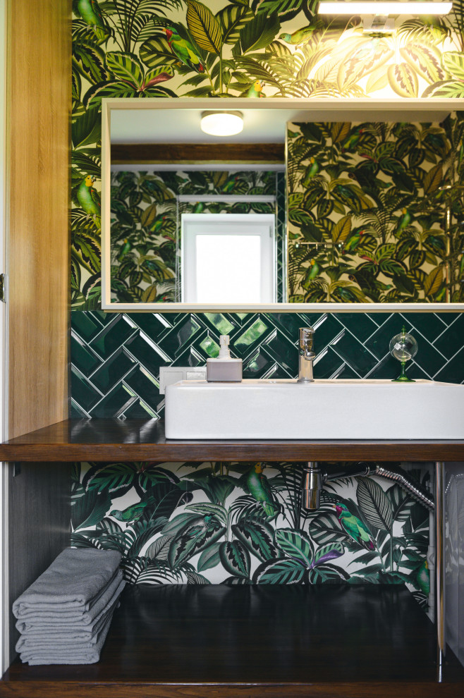 Стильный дизайн: маленькая ванная комната со стиральной машиной в современном стиле с коричневыми фасадами, душем в нише, унитазом-моноблоком, зеленой плиткой, керамогранитной плиткой, зелеными стенами, полом из керамогранита, душевой кабиной, накладной раковиной, столешницей из дерева, бежевым полом, душем с распашными дверями, коричневой столешницей, тумбой под одну раковину, подвесной тумбой, балками на потолке и обоями на стенах для на участке и в саду - последний тренд