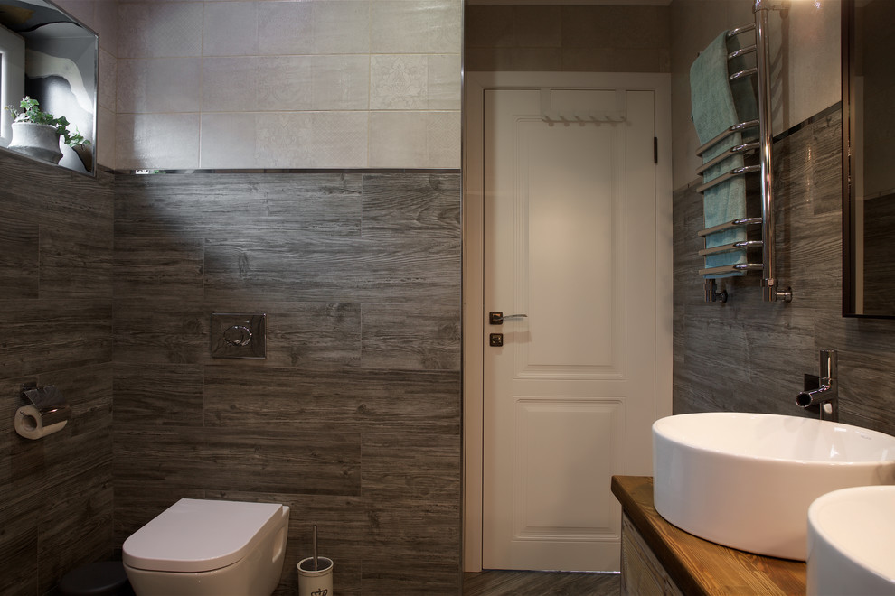 Medium sized contemporary shower room bathroom in Other with flat-panel cabinets, medium wood cabinets, a wall mounted toilet, grey tiles, porcelain tiles, grey walls, porcelain flooring, a built-in sink, wooden worktops, grey floors, a hinged door and brown worktops.
