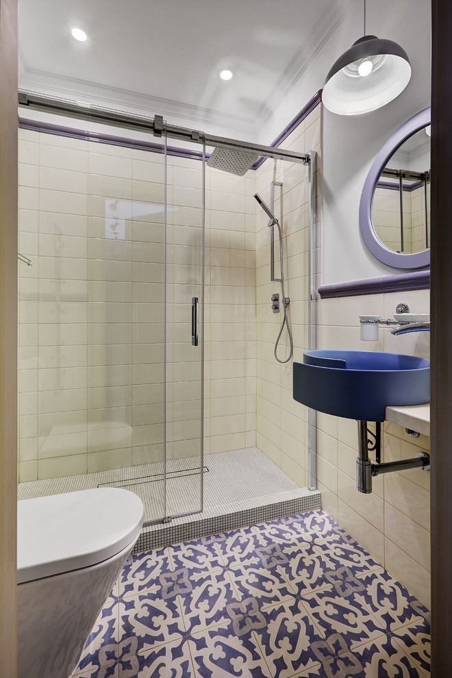 Modelo de cuarto de baño contemporáneo con ducha empotrada, baldosas y/o azulejos blancos, paredes blancas, aseo y ducha, lavabo suspendido, suelo azul, ducha con puerta corredera y espejo con luz