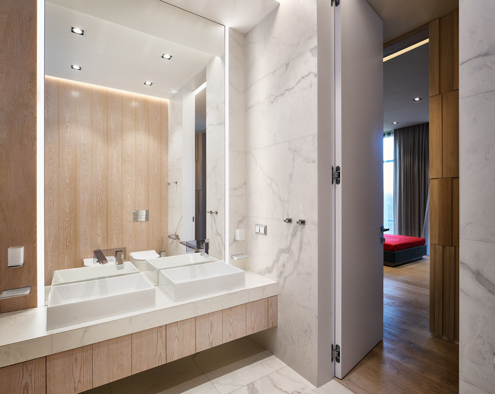 Esempio di una stanza da bagno design di medie dimensioni con ante lisce, ante in legno chiaro, piastrelle bianche, piastrelle in gres porcellanato, pavimento in gres porcellanato, lavabo a bacinella, pavimento bianco e top bianco
