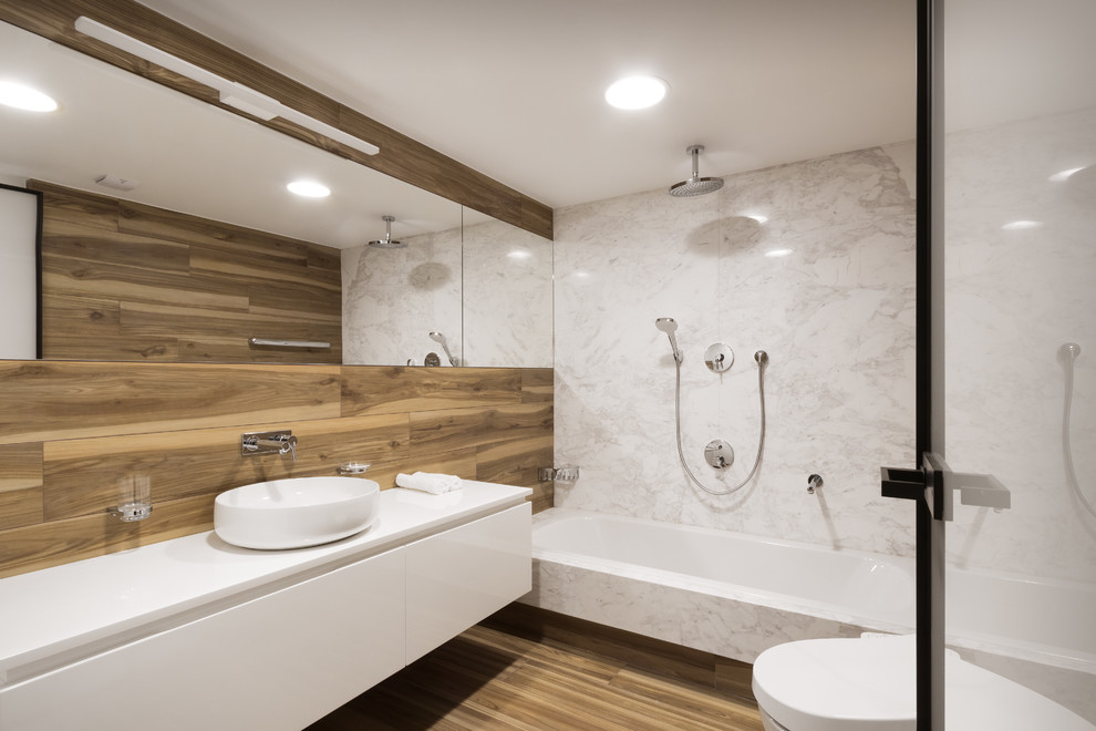 Стильный дизайн: главная ванная комната с полновстраиваемой ванной, душем над ванной, инсталляцией, мраморной плиткой, полом из керамогранита, столешницей из искусственного камня, открытым душем и белой столешницей - последний тренд