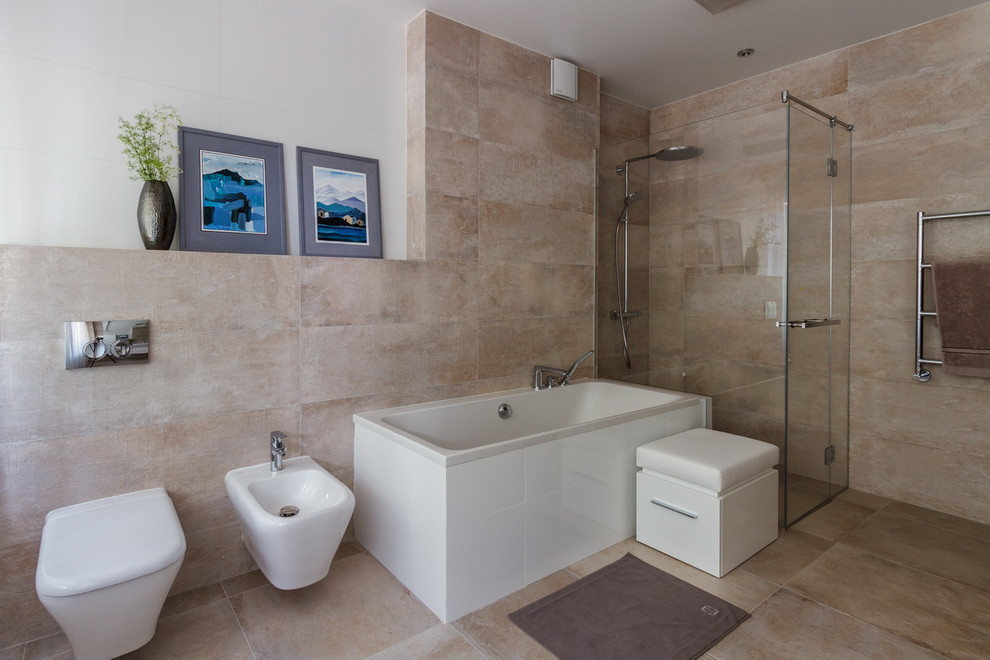 На фото: большая главная ванная комната в современном стиле с полновстраиваемой ванной, инсталляцией, керамогранитной плиткой, бежевыми стенами, полом из керамогранита, бежевым полом, душем с распашными дверями, белыми фасадами и бежевой плиткой