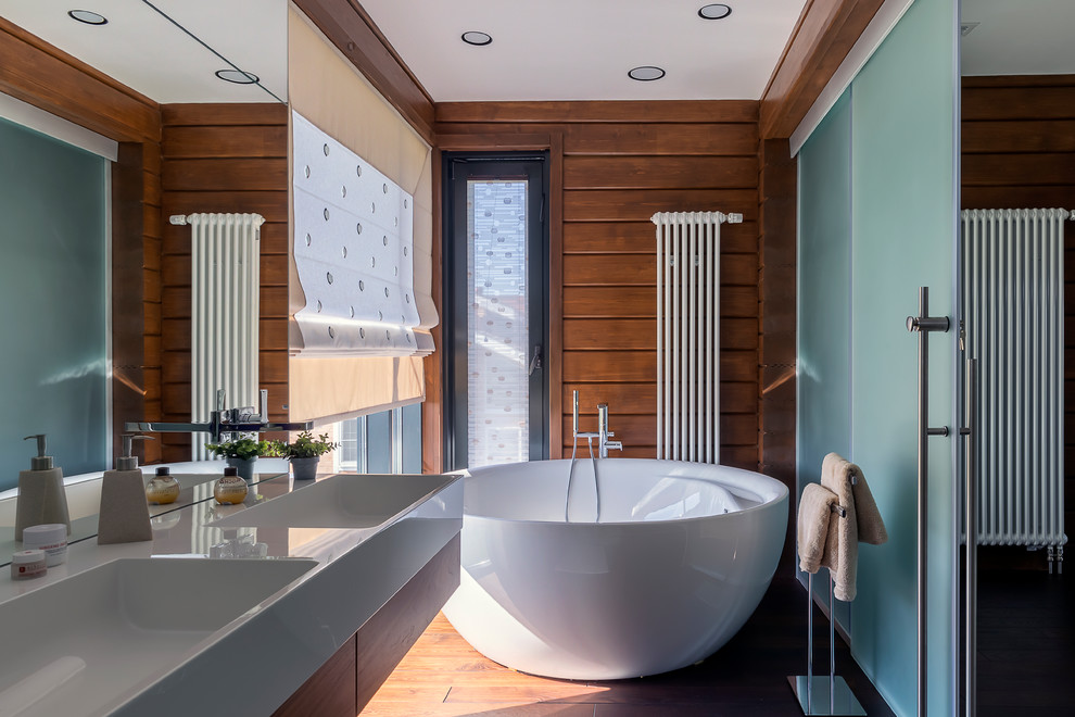 Exempel på ett modernt en-suite badrum, med ett fristående badkar, släta luckor, skåp i mellenmörkt trä, bruna väggar, mellanmörkt trägolv, ett integrerad handfat och brunt golv