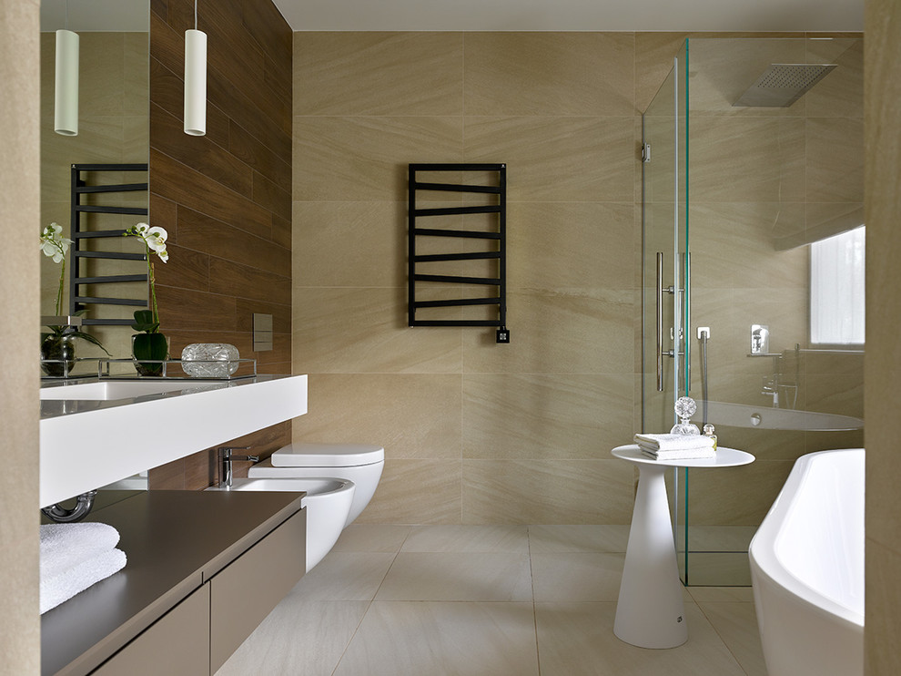 Cette image montre une salle de bain design avec un placard à porte plane, des portes de placard marrons, une baignoire indépendante, une douche d'angle, un bidet, un carrelage beige, un lavabo intégré, un sol beige, une cabine de douche à porte battante et un plan de toilette blanc.