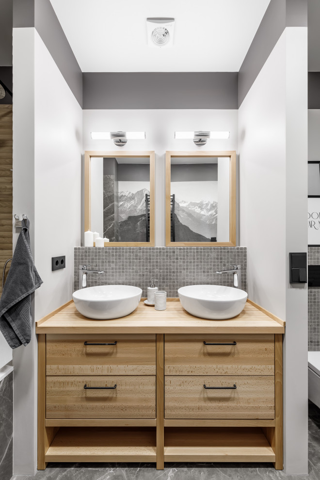 Design ideas for a medium sized traditional shower room bathroom in Saint Petersburg with flat-panel cabinets, light wood cabinets, grey tiles, white walls, porcelain flooring, a vessel sink, wooden worktops, grey floors, beige worktops, double sinks and a built in vanity unit.