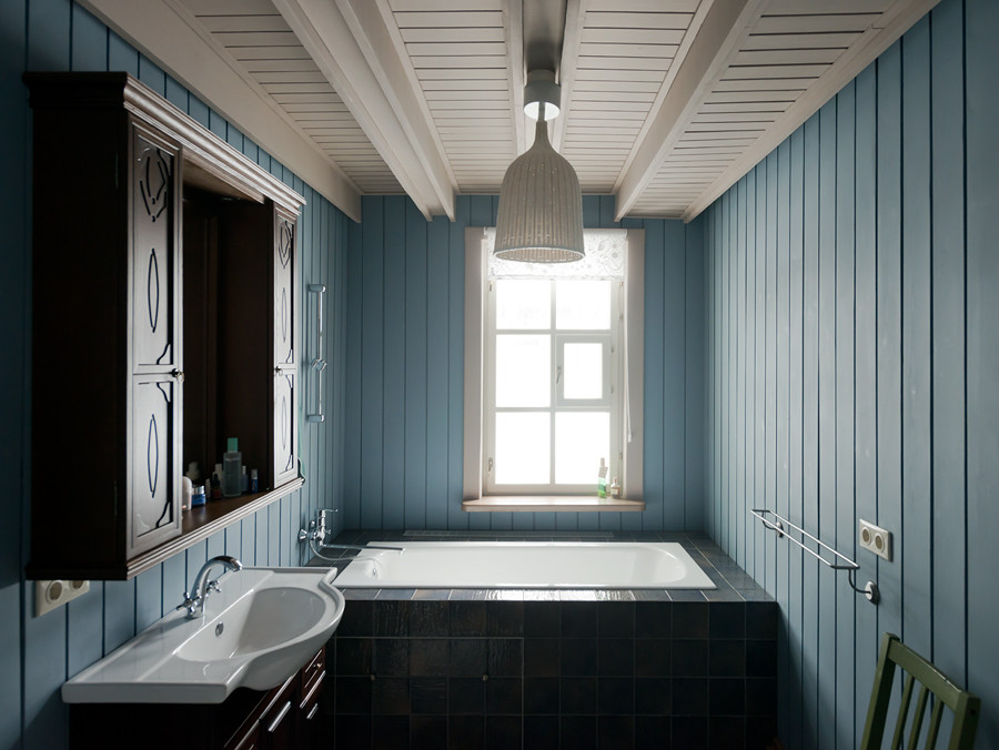 Пример оригинального дизайна: главная ванная комната среднего размера в стиле кантри с фасадами с выступающей филенкой, фасадами цвета дерева среднего тона, синими стенами, полом из керамической плитки, накладной раковиной, столешницей из дерева и ванной в нише