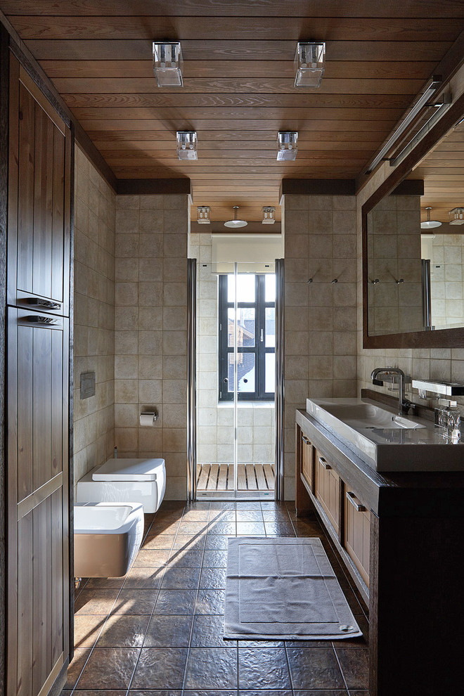 Modelo de cuarto de baño campestre con ducha empotrada, sanitario de pared, aseo y ducha y suelo marrón