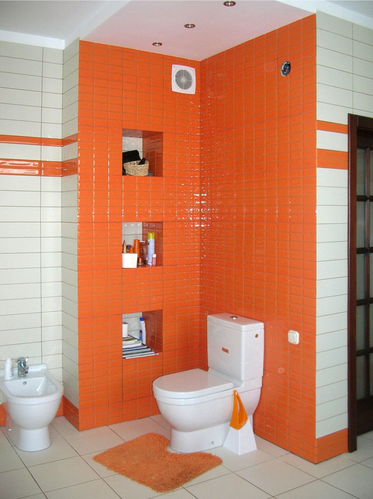 Стильный дизайн: большая главная ванная комната в стиле фьюжн с оранжевыми фасадами, гидромассажной ванной, раздельным унитазом, оранжевой плиткой, плиткой кабанчик, белыми стенами, полом из керамической плитки и подвесной раковиной - последний тренд