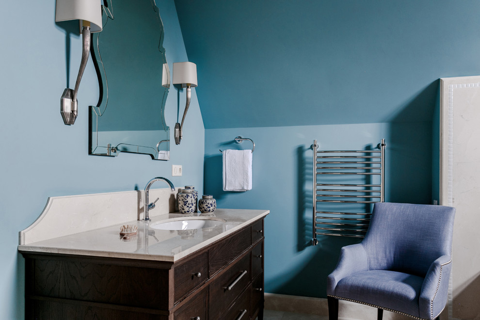 Ejemplo de cuarto de baño clásico con puertas de armario de madera en tonos medios, paredes azules y lavabo bajoencimera