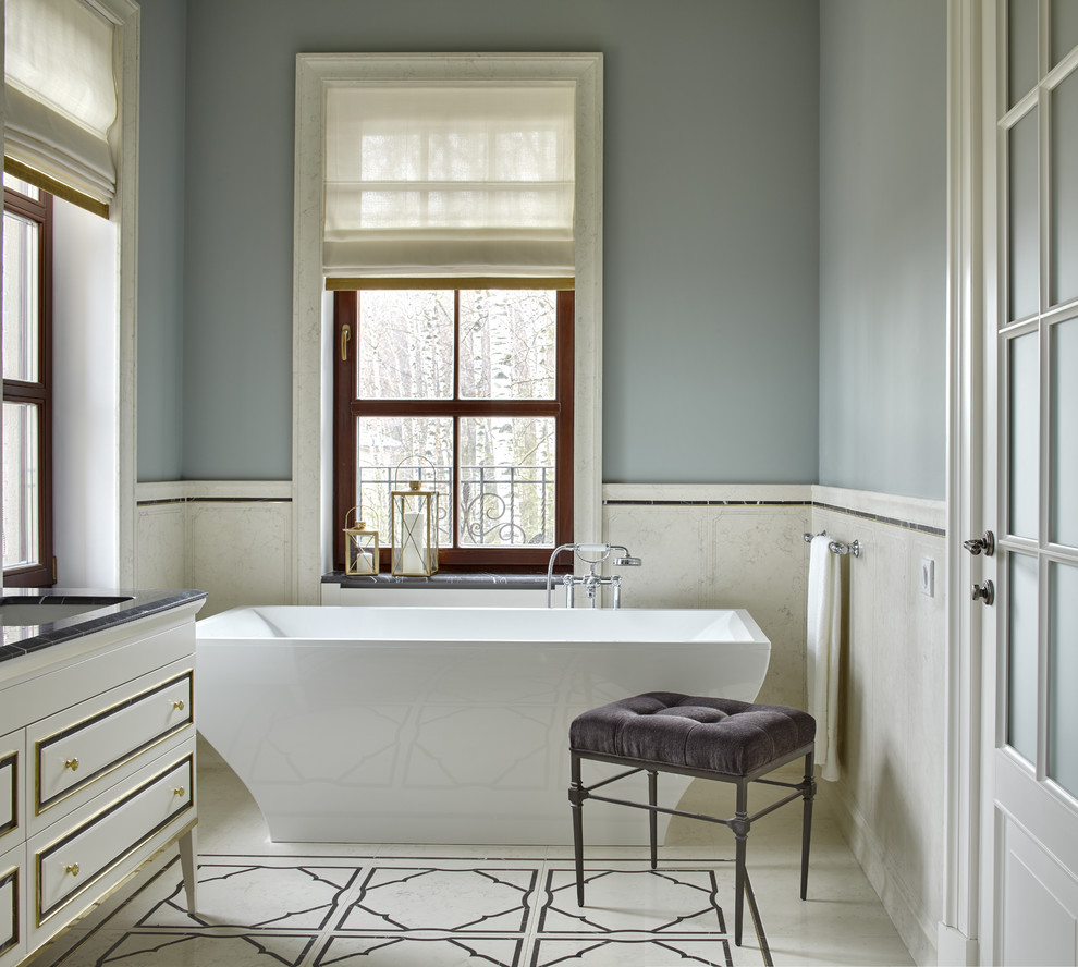 Exemple d'une salle de bain principale chic avec une baignoire indépendante et un mur gris.