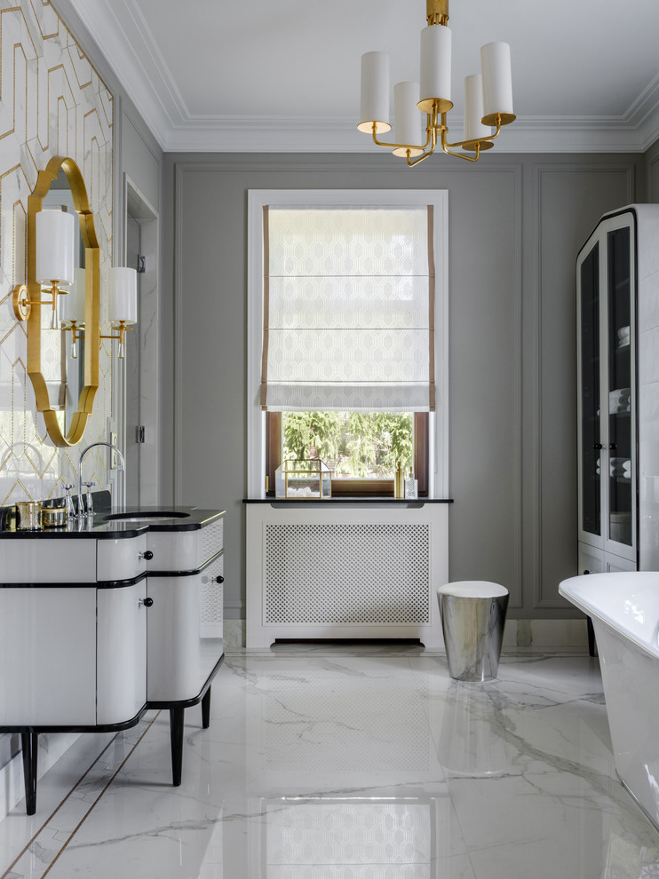 На фото: главная ванная комната в стиле неоклассика (современная классика) с белыми фасадами, врезной раковиной, белым полом и черной столешницей с