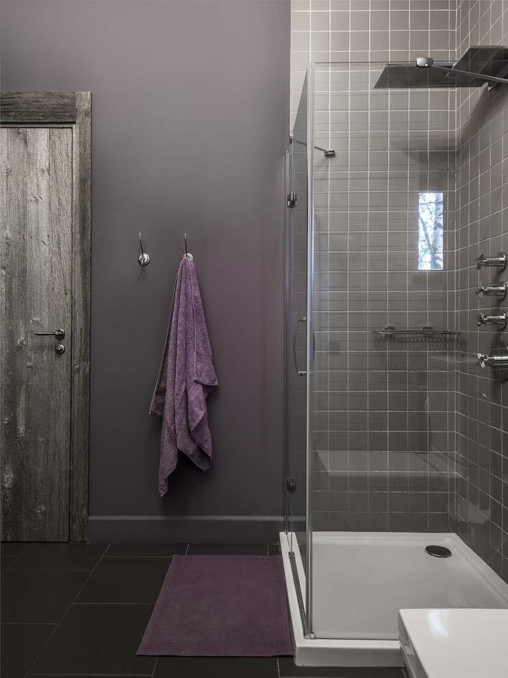 На фото: ванная комната в современном стиле с серой плиткой, фиолетовыми стенами, душевой кабиной, черным полом и душем с распашными дверями с