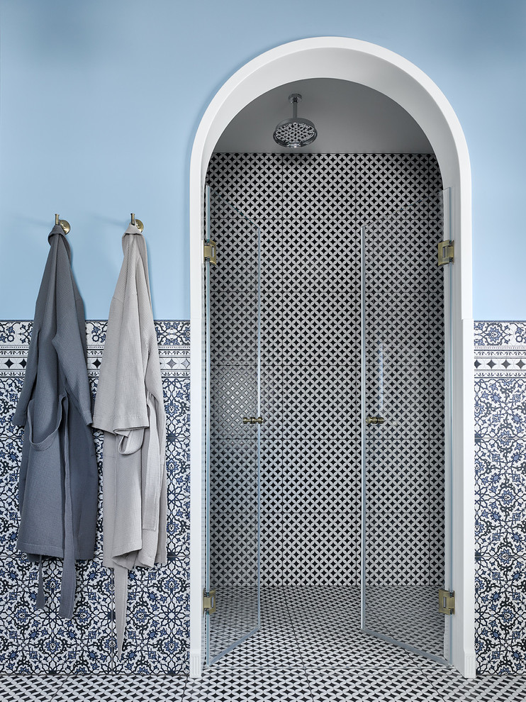 Ejemplo de cuarto de baño mediterráneo con paredes azules, aseo y ducha y ducha con puerta con bisagras