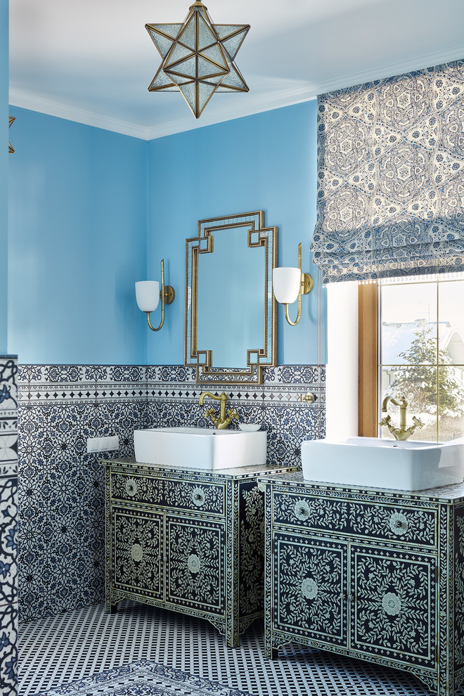 Immagine di una stanza da bagno mediterranea con pareti blu e lavabo a bacinella